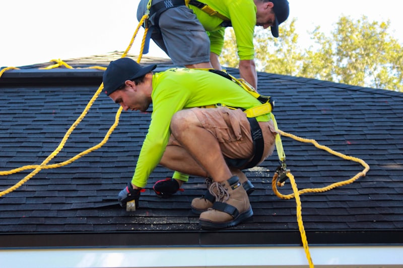Roofers installing asphalt shingles on a roof